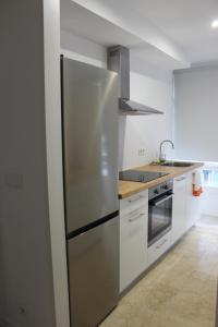 a stainless steel refrigerator in a white kitchen at XELIÑA c in A Estrada +12 photos