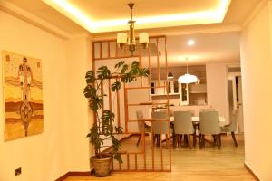 a dining room and living room with a table and a plant at 5 Bedroom Exquisite Villa in Top-view Area in Addis Ababa