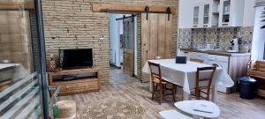 una cucina con tavolo, sedie e TV di L'Oustal a Montech