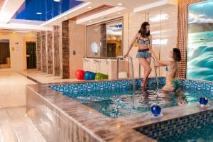two women standing in a swimming pool at Grand Hill Hotel Ulaanbaatar in Ulaanbaatar