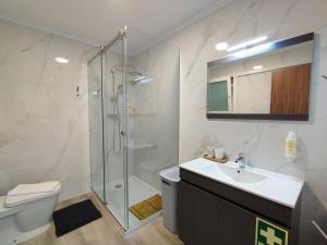 a bathroom with a shower and a sink and a toilet at Apartamento SEREN AGUA in Moledo +45 photos