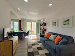 a living room with a blue couch and a dining room at Apartamento SEREN AGUA in Moledo