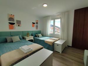 a bedroom with two beds and a window at Apartamento SEREN AGUA in Moledo