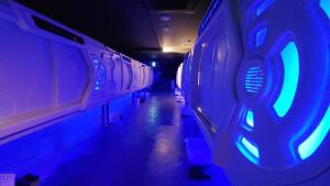 an empty train car with blue lights on it at Hotel Galaxy Pod 北越谷店 in Koshigaya