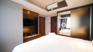 Postel nebo postele na pokoji v ubytování Modern and Cozy 2BR at Grand Sungkono Lagoon Apartment By Travelio + 18 fotografií