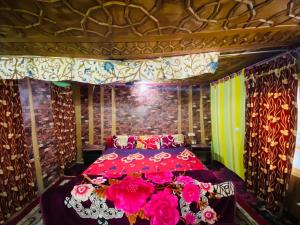 a bedroom with a red bed with pink flowers at Island homestay in dal lake in Srinagar