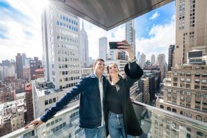 a man and woman taking a picture on a skyscraper at Pestana Park Avenue in New York
