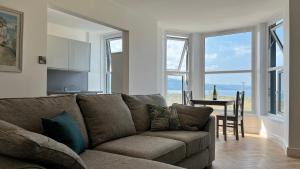 una sala de estar con un sofá y una mesa en Barmouth Beach Front Apartments, en Barmouth