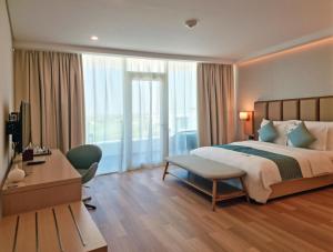 a hotel room with a bed and a desk and a room at Zoya Health & Wellbeing Resort in Ajman 