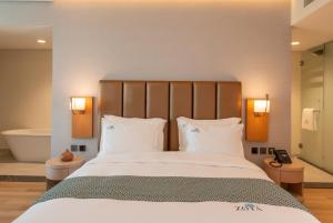 a bedroom with a large bed and a bath tub at Zoya Health & Wellbeing Resort in Ajman  +57 photos