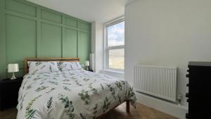 Un dormitorio con una cama y una ventana grande. en Barmouth Beach Front Apartments, en Barmouth