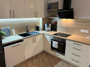 a kitchen with white cabinets and a sink and a stove at Marijas Apartment with Comfort for 5 in Rīga