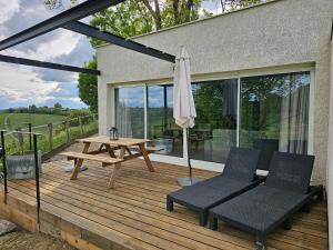 a wooden deck with a picnic table and an umbrella at Domaine de Massoulac in Molières