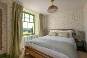 En eller flere senge i et værelse på Queensberry Cottage