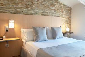 een slaapkamer met een bed met witte lakens en kussens bij Olympia Consul del Mar in Valencia