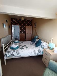 Un dormitorio con una cama grande con almohadas azules. en Heatherlea, en Grange-over-Sands 15 fotos más