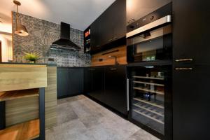 a kitchen with black cabinets and a wine cellar at Villa VEGA - Gorseti in Gornji Šajn