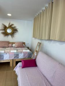a bedroom with a bed and a couch with a mirror at ALZIRA BONITA Apto con terraza y cama balinesa les barraques in Alzira