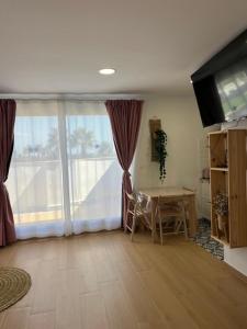 a living room with a table and a large window at ALZIRA BONITA Apto con terraza y cama balinesa les barraques in Alzira