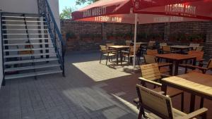 a restaurant with tables and chairs and an umbrella at Pensiunea 82 in Nădlac
