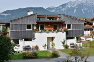 a house in the mountains with mountains in the background at Demeterhof Knolln in Söll
