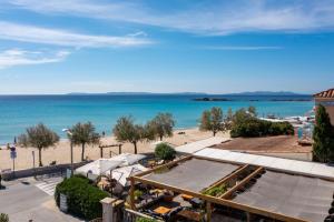 a view of the beach and the ocean at Hotel Les Flots Bleus in Le Lavandou