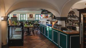 a restaurant with a bar with green cabinets and tables at Noon Mirch Hotel Restaurant in Eching