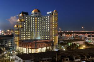 un gran edificio con luces encendidas en una ciudad por la noche en Al Meroz Hotel Bangkok - The Leading Halal Hotel, en Bangkok