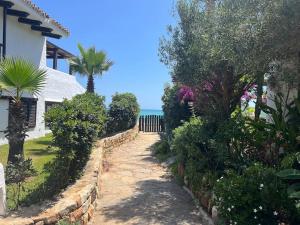 a pathway leading to a house with trees and bushes at Kabila Marina 2 Beach Haven - Your Coastal Escape in M'diq