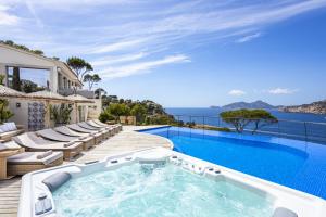 a villa with a swimming pool and the ocean at Villa Mimosa in Andratx