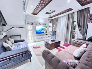 a living room with two couches and a flat screen tv at Villa Contenental residense El sheikh Zayed Beverly Hills in Sheikh Zayed