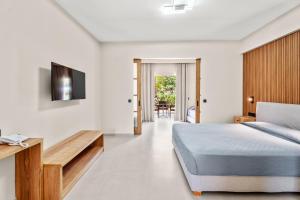 una camera con letto e TV a parete di Aqualand Resort ad Ágios Ioánnis Altre 10 foto