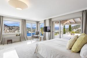 a bedroom with a large bed and large windows at Villa Mimosa in Andratx +31 photos