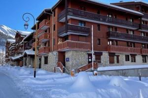 a building with a lot of snow in front of it at Jardins de Val Le charme à la Montagne in Val dʼIsère