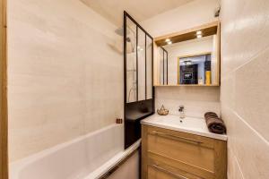 a bathroom with a sink and a bath tub at Jardins de Val Le charme à la Montagne in Val dʼIsère +7 photos