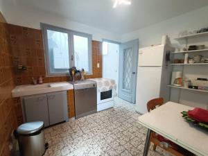 kuchnia ze zlewem i lodówką w obiekcie Maison de Famille Vintage à 100m de la Plage 10ARGO82 w mieście Saint Pierre La Mer