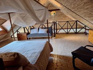 a bedroom with a bed and a chair in a room at Exceptional house with sea view in Cap Skirring in Boukot Ouolof