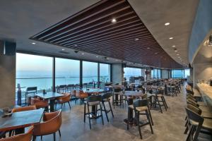a restaurant with tables and chairs and windows at Grand Sapphire Residence By Aircyp in Iskele