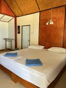 a large bed with two blue towels on it at Pansand Resort in Ko Bulon Le