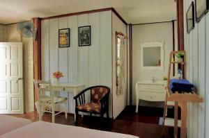a bedroom with a bed and a desk and a chair at Pansand Resort in Ko Bulon Le