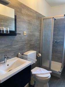 a bathroom with a sink and a toilet and a shower at Pension Haus Meeresgruss in Cuxhaven +5 photos