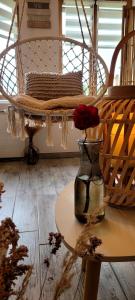 Eine Vase mit einer Rose auf einem Tisch in der Unterkunft Cottage Interieur Spa classé 4 étoiles - balnéo et sauna privatif in Tannay