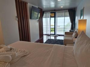 a bedroom with a white bed and a living room at Nangyuan Island Dive Resort in Ko Tao