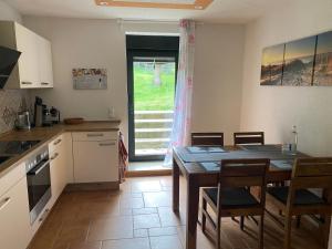 a kitchen with a table and chairs and a window at Ferienwohnung auf dem Gutshof Renz in Weißenfels