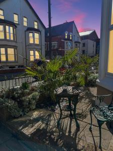 a patio with two chairs and a table with plants at Granada Apartments at Pleasure Beach in Blackpool
