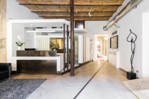a living room with white walls and a wooden ceiling at Hotel La Rovere in Rome