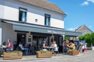 a group of people sitting at tables outside of a building at Auberge de la boucle in Moisson +16 photos