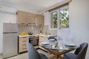 a kitchen with a glass table and chairs in a kitchen at Gkountis Garden Studio in Tsoukaladhes