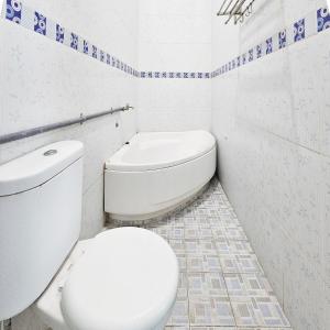 a white bathroom with a toilet and a sink at Ijen Homestay Mojokerto RedPartner in Mojokerto