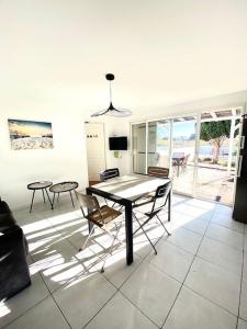 a dining room with a table and some chairs at Maison, jardinet, terrasse, parking privée, climatisation in Saintes-Maries-de-la-Mer